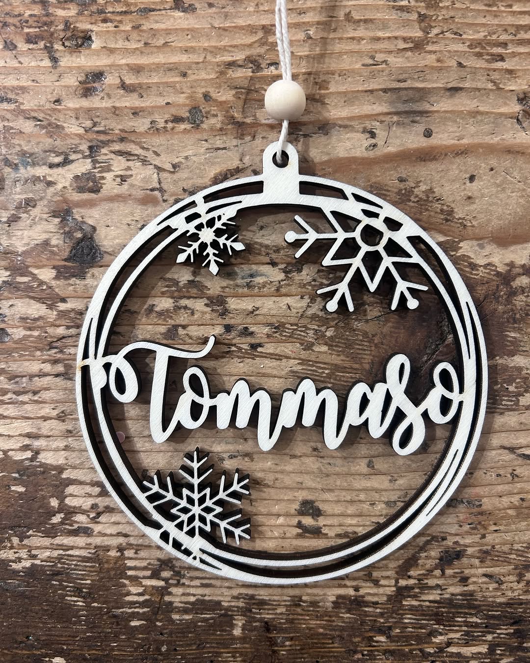 Ornamento natalizio in legno traforato col nome Tommaso e fiocchi di neve, tagliato a laser